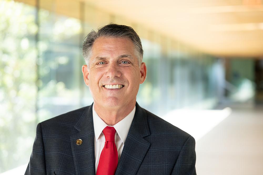 BSU president Fred Clark smiling for the camera in a sunlit corridor